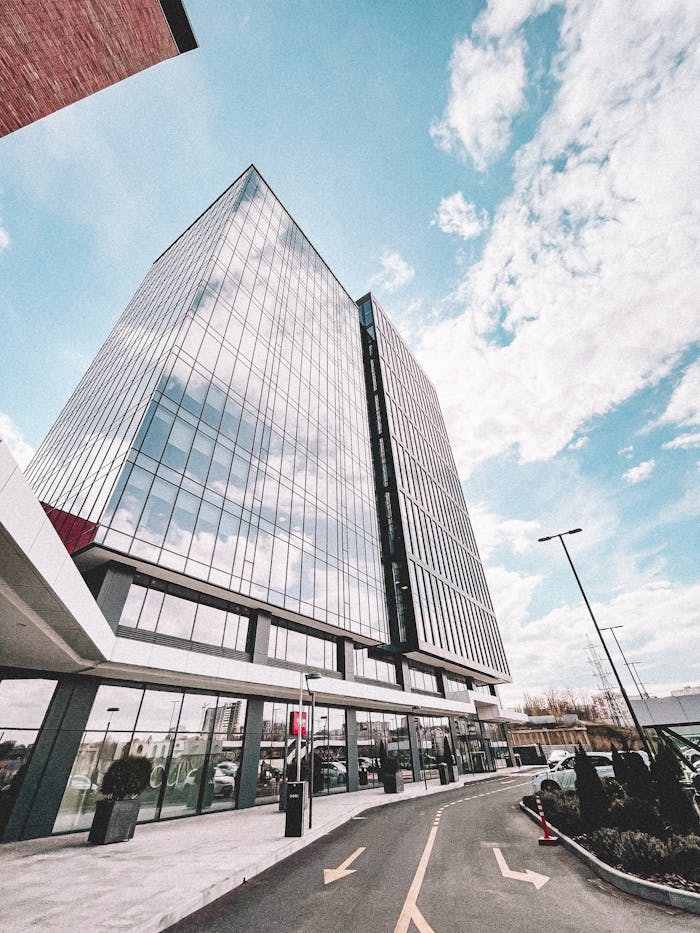 Contemporary glass office tower reflecting the sky, showcasing modern architectural design.